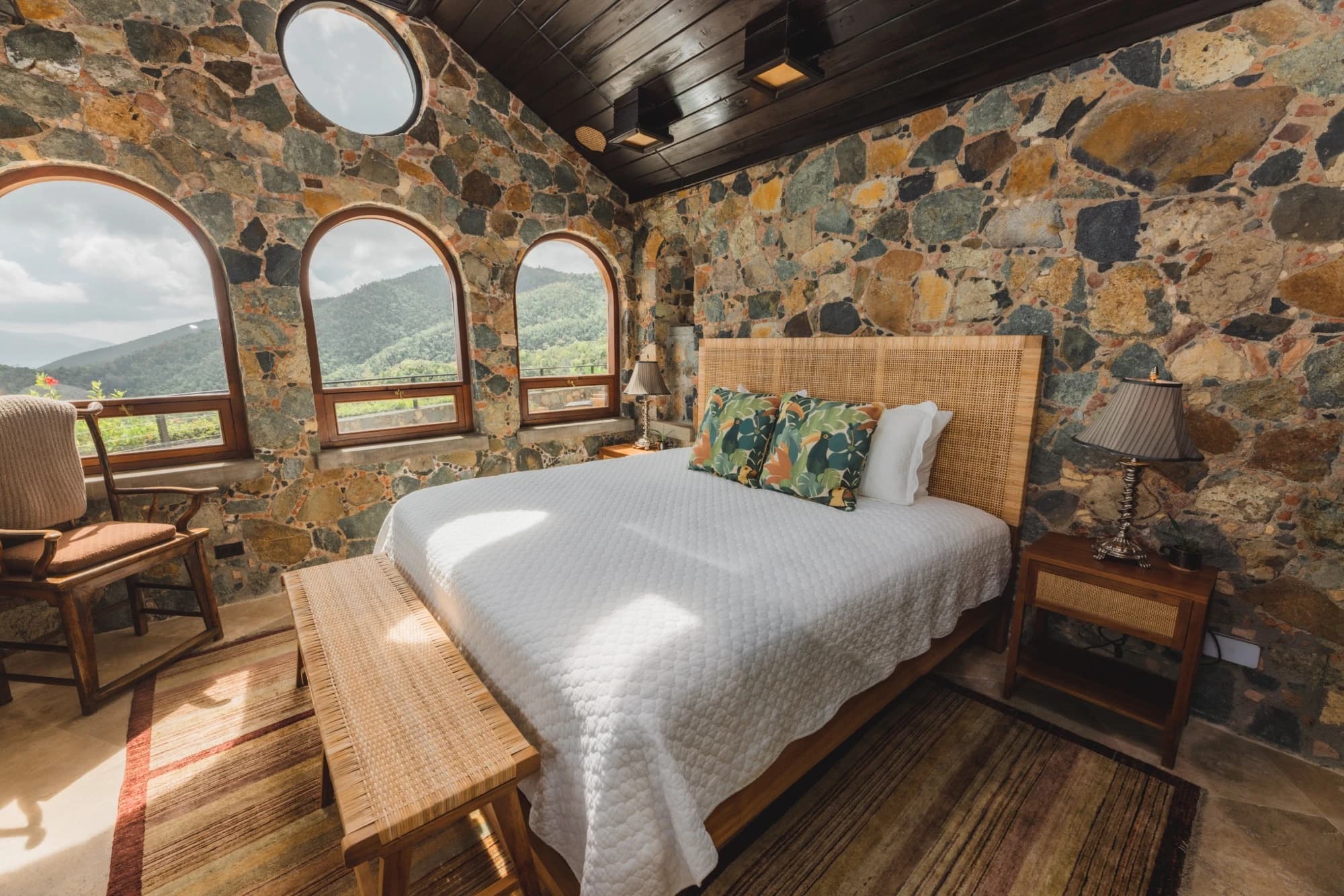 Mountain view bedroom with dark wood ceiling and stone walls at Valhalla St John