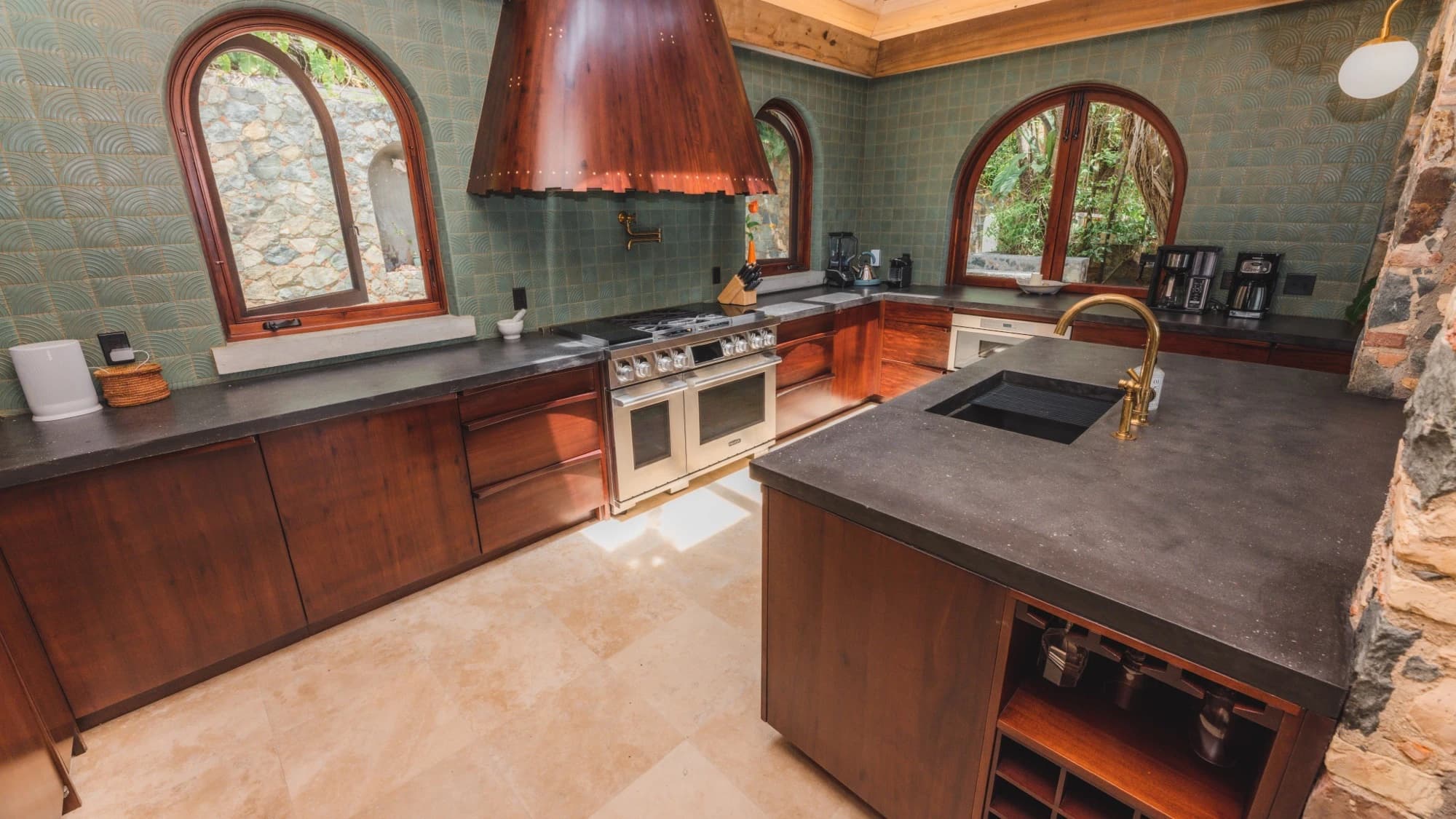 Gourmet kitchen with copper range hood, professional stove, and island at Valhalla St John