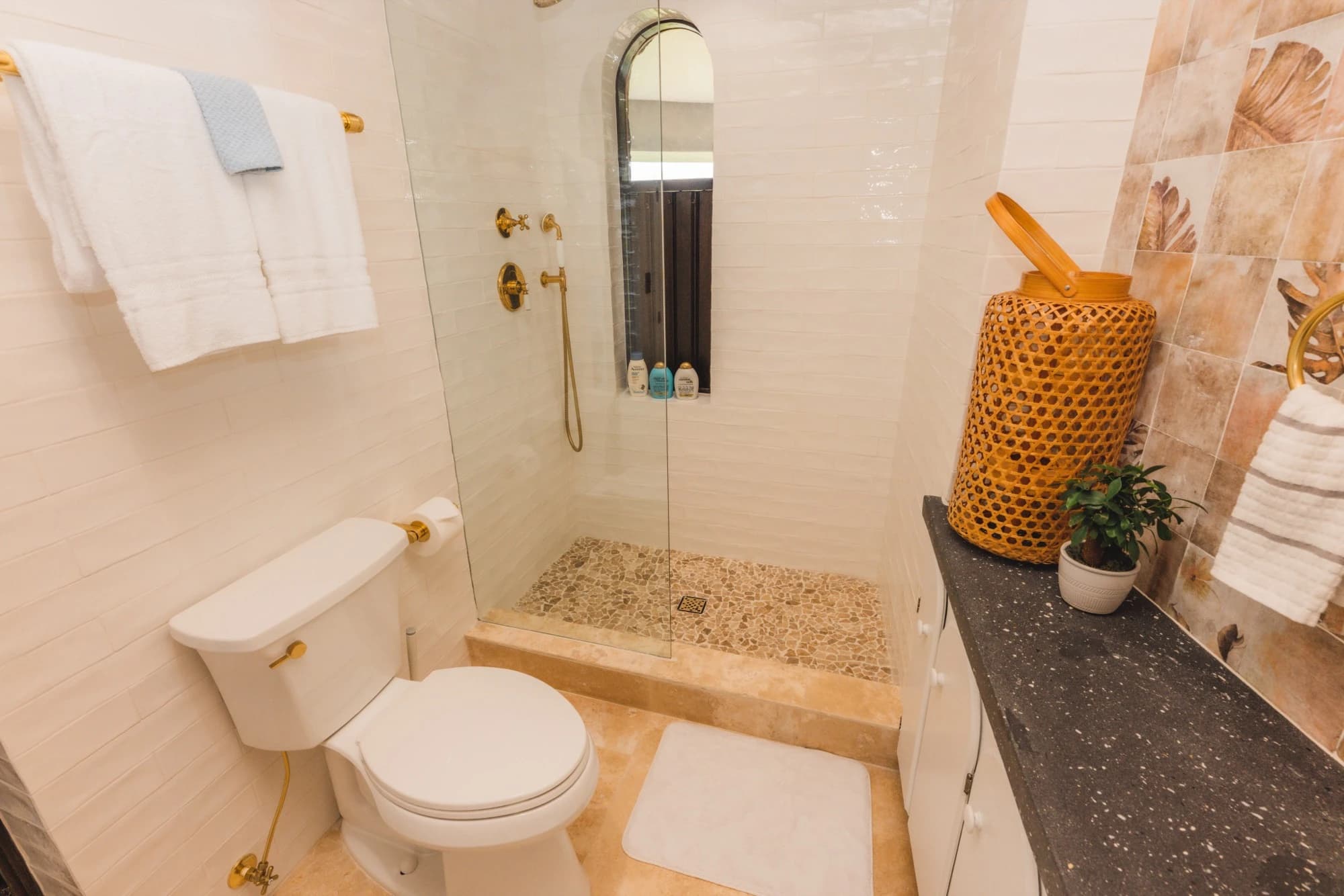 Modern bathroom with white tile and gold fixtures at Valhalla St John villa