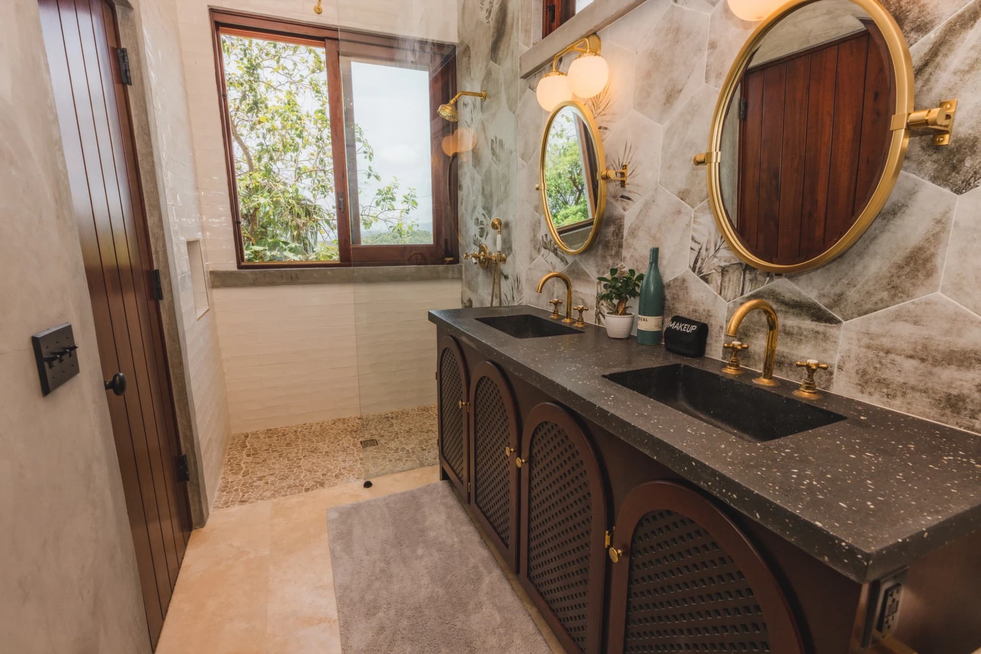 Double vanity bathroom with round gold mirrors at Valhalla St John